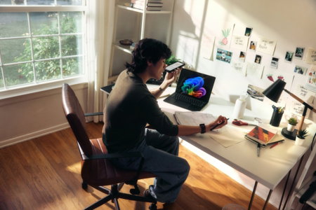 person-working-at-a-desk-with-a-laptop-and-books-.jpg Person working at a desk with a laptop and books.